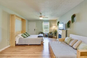 A bedroom with two beds, a ceiling fan, a TV, and a fireplace. - Walk to Grand Lagoon! Couples Haven 2 Mi to Beach (Panama City Beach)