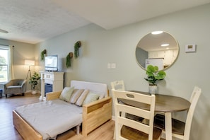 A cozy room with a bed, a dining table, a chair, a TV, and a mirror. - Walk to Grand Lagoon! Couples Haven 2 Mi to Beach (Panama City Beach)