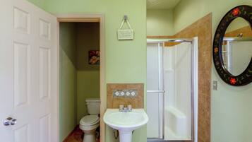 Un baño con inodoro, lavamanos y ducha.