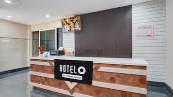 A hotel reception desk with a sign indicating it is a company-serviced hotel.
