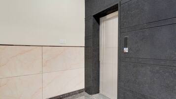 Un couloir doté d’un sol en marbre, d’une porte et d’un mur à la finition texturée.