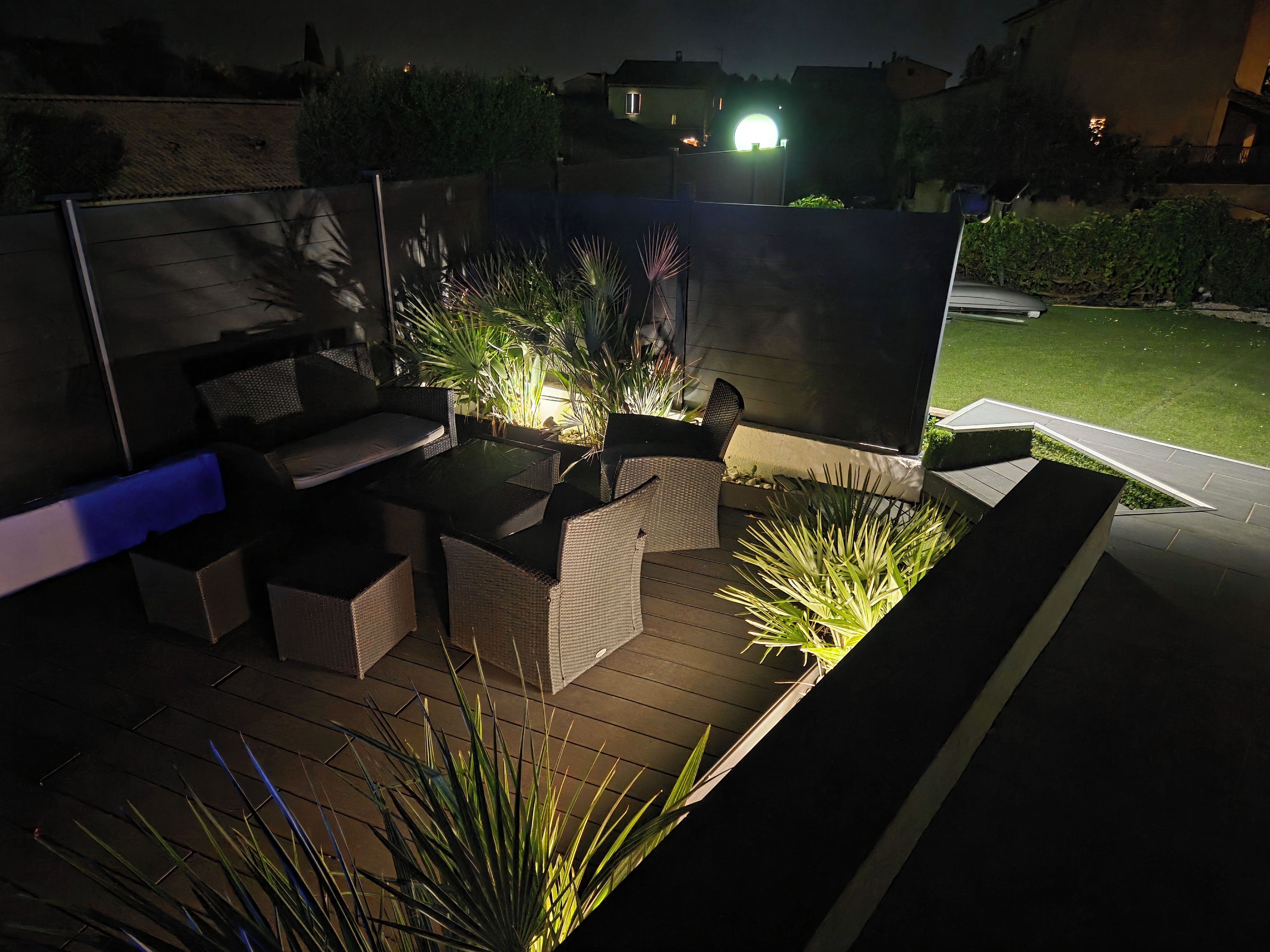 Un espace extérieur aménagé en terrasse, avec des sièges et des jardinières.