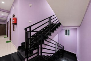 A staircase with black railings in a room with purple walls.