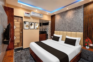 Ein Hotelzimmer mit einem Bett, einem Fernseher, einer Klimaanlage und einem Kunstwerk an der Wand.