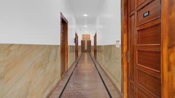 Un pasillo con puertas de madera, un extintor y un cartel que indica la habitación 101.