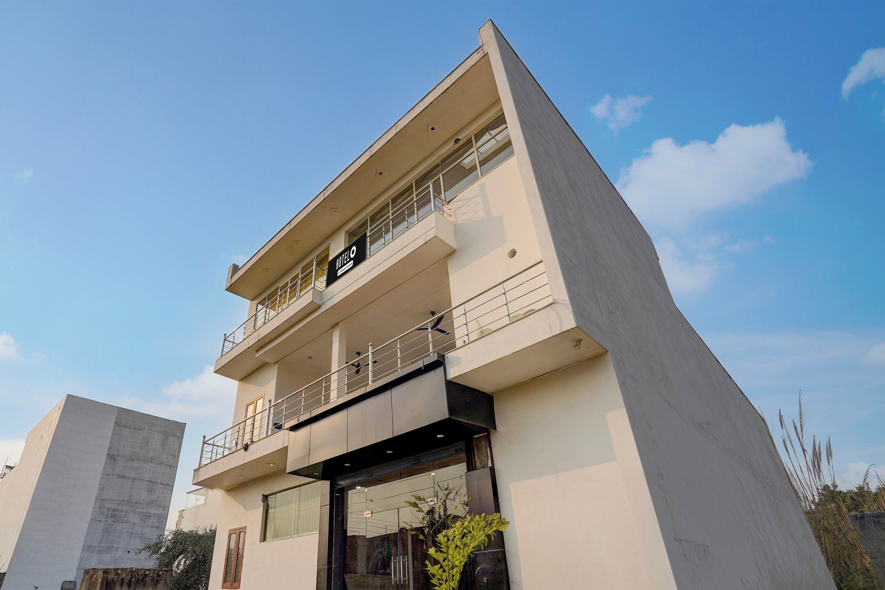 Un edificio moderno de hotel con fachada plana, varios balcones y un letrero que indica que es un hotel.