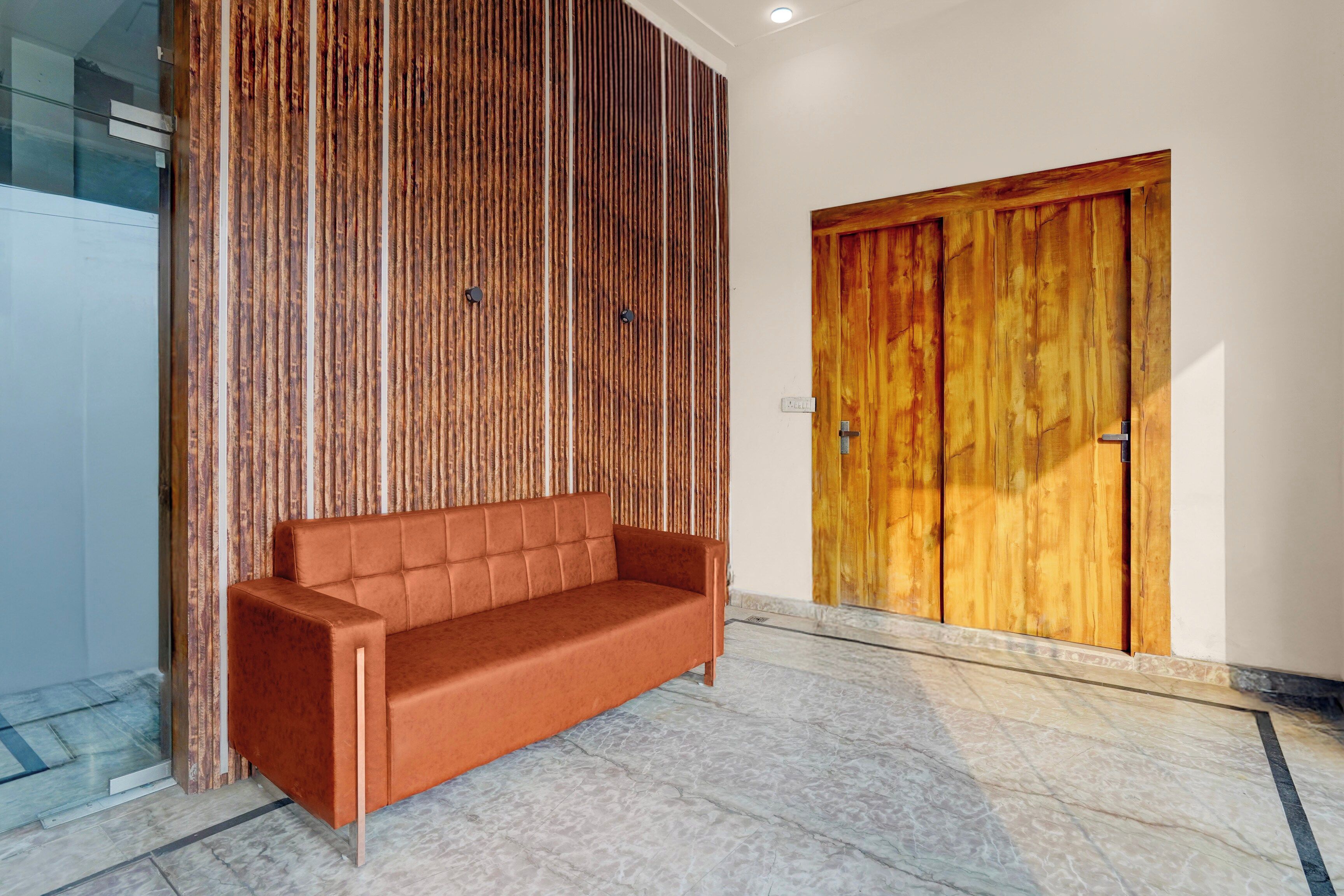Un interior moderno con un panel de madera, un sofá de cuero marrón y una puerta de madera.