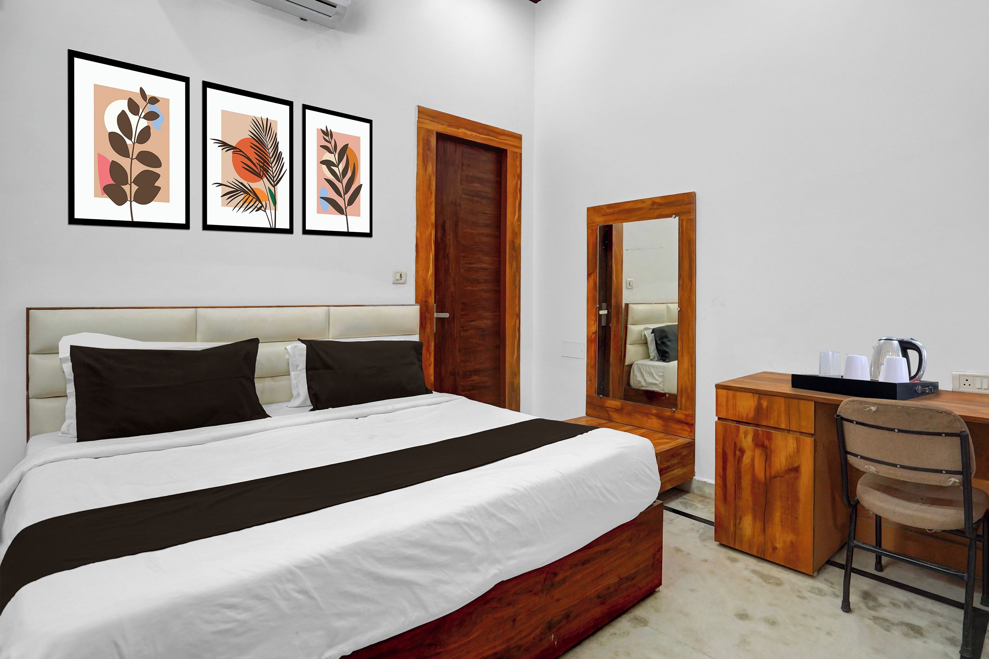 Un dormitorio ordenado con cama, escritorio y espejo.
