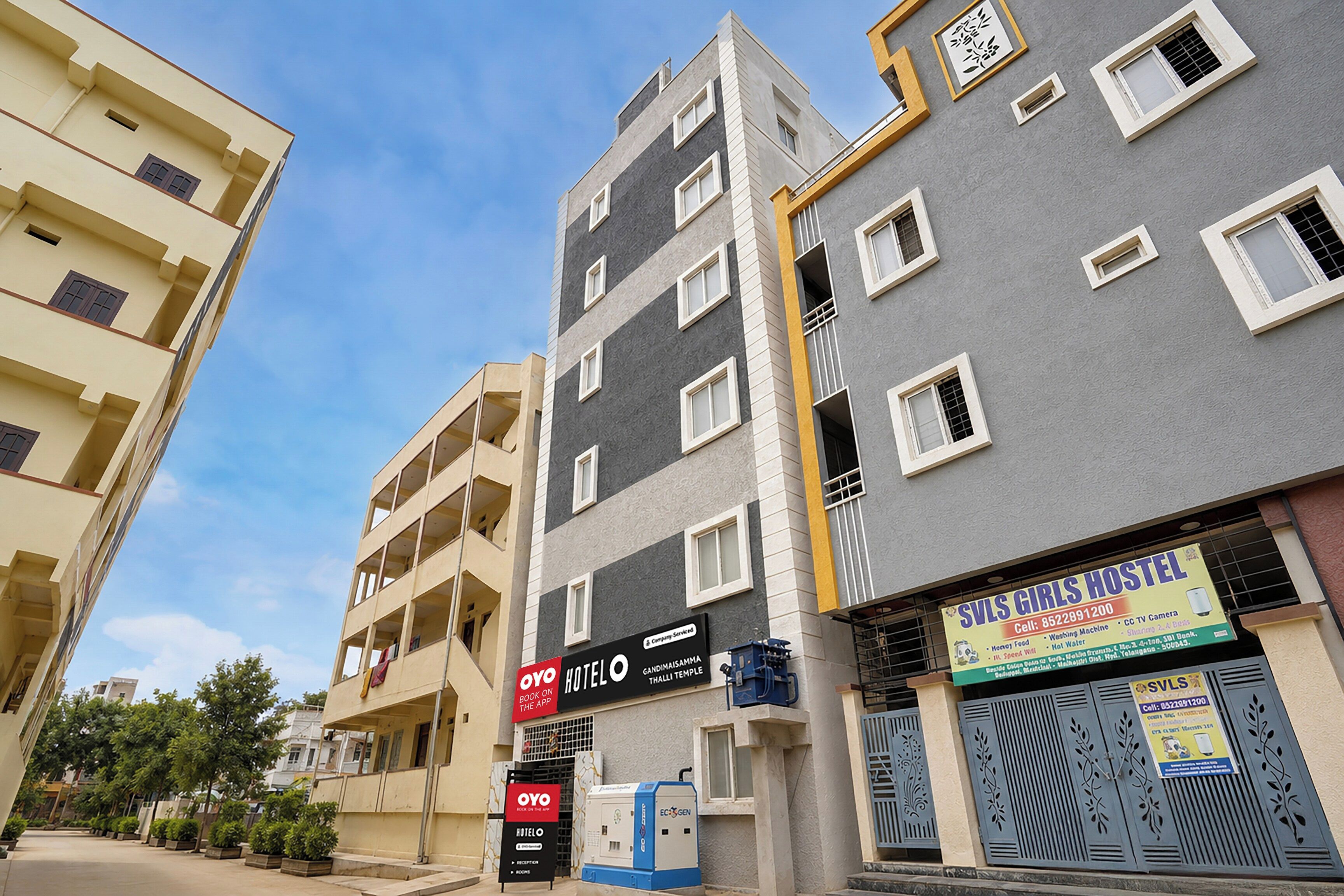 Un hotel de varios pisos con balcones, un letrero que indica un albergue juvenil y un cuadro eléctrico visible.