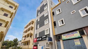 Un hotel de varios pisos con balcones, un letrero que indica un albergue juvenil y un cuadro eléctrico visible.