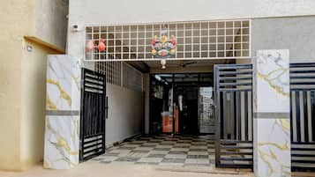 A building entrance with a checkered floor, metal gates, and a decorative emblem above the entrance.