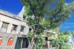 Un edificio con varias ventanas y puertas, rodeado de árboles.