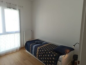 A small, single-bed room with a window, a radiator, and a desk lamp. - Les Hauts de la Collégiale (4 people) Terrace with a view of Mont Blanc & free parking. (Sallanches)