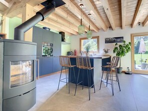 A modern kitchen with a built-in stove, bar stools, and a large window. - Le Vivier (6 People) A peaceful setting with a view of the mountains. Private parking (Saint-Gervais-les-Bains)