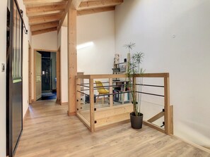 A wooden staircase with a glass enclosure, a potted plant, and a yellow chair in a hallway with wooden flooring. - Le Vivier (6 People) A peaceful setting with a view of the mountains. Private parking (Saint-Gervais-les-Bains)