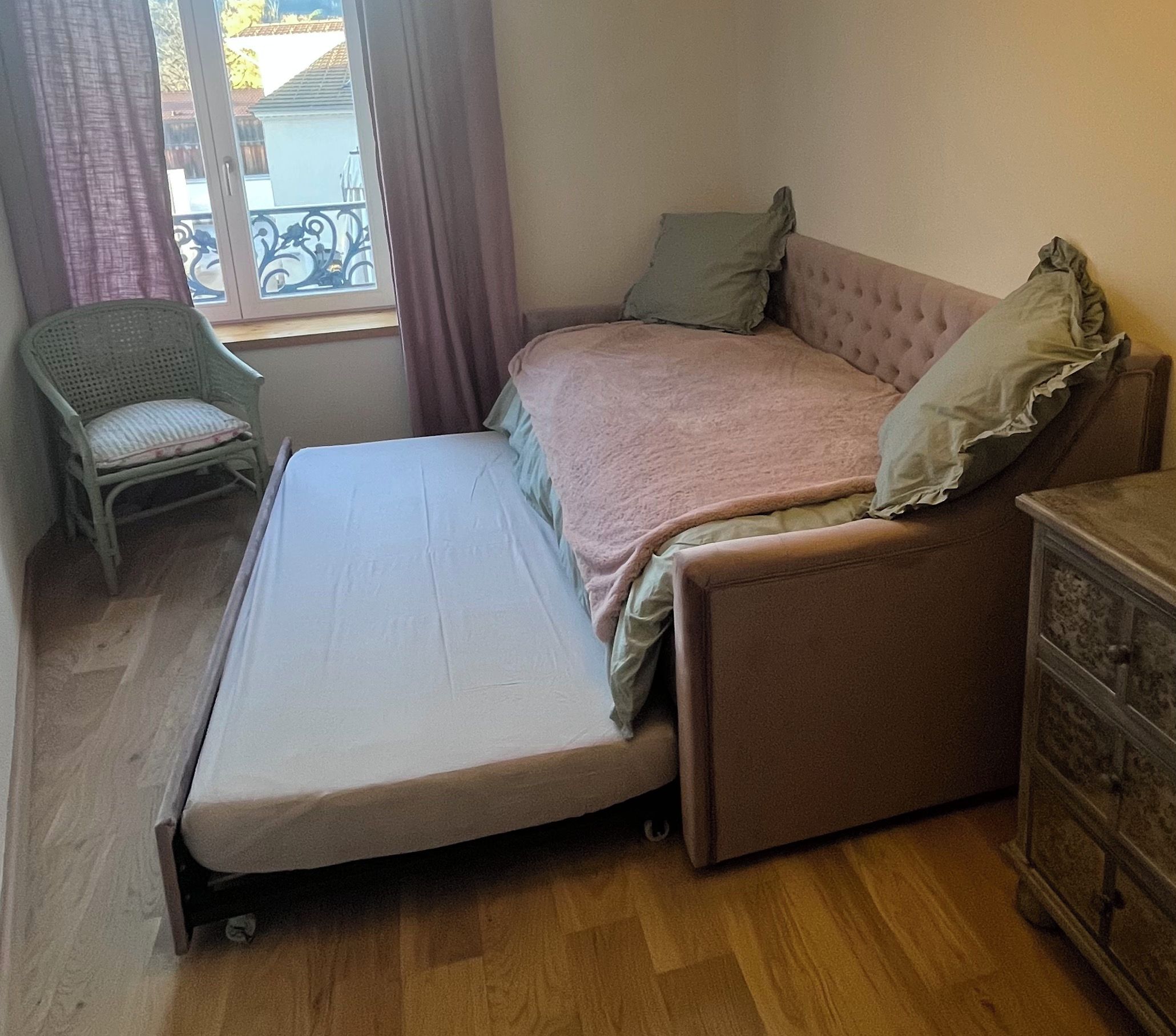 A compact room with a bed, a chair, and a dresser.