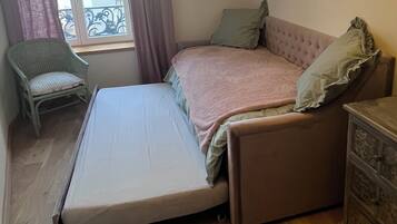 A compact room with a bed, a chair, and a dresser.