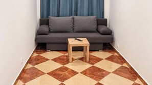 A small room with a sofa and a wooden table. - Vienna at Your Pace 1BR and Living Room (Vienna)