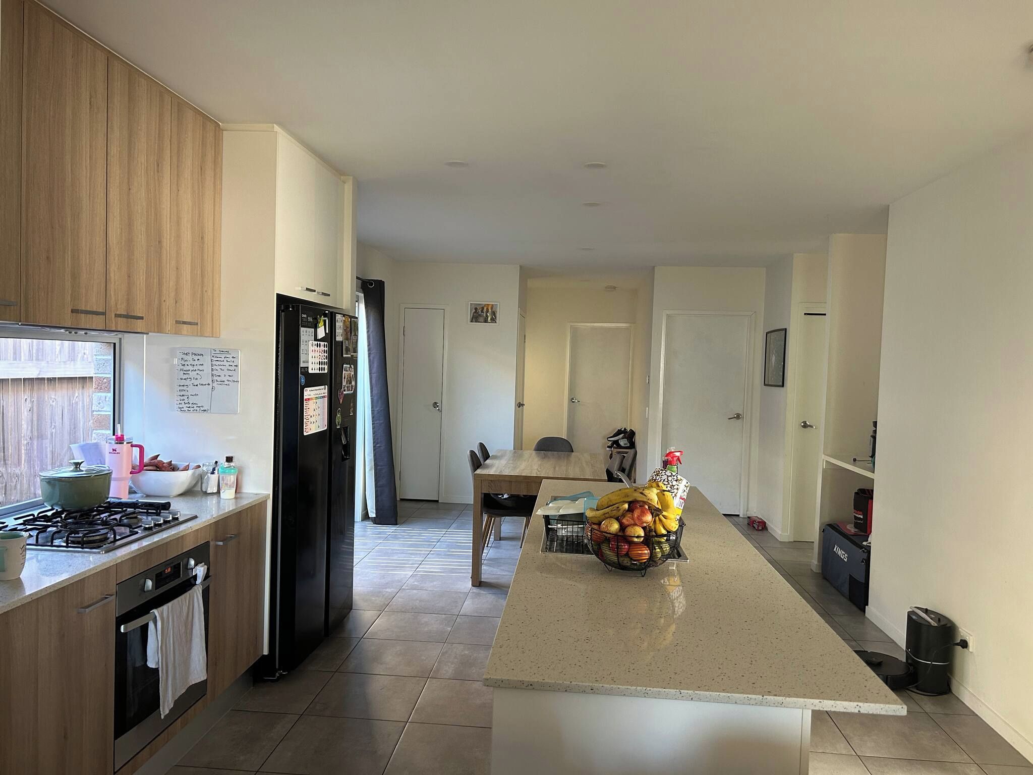 A modern kitchen with a central island, stainless steel appliances, and a tiled floor.