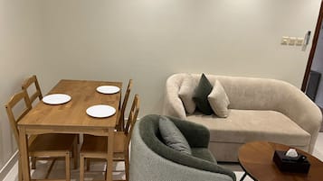 A dining table with four white plates and a wooden chair.