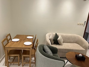 A dining table with four white plates and a wooden chair.