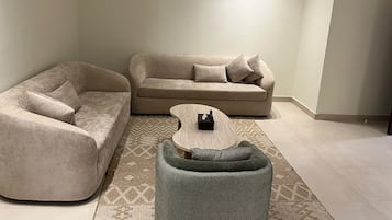 Una sala de estar con un sofá, una mesita de centro y una alfombra estampada.