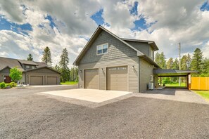 Une maison à deux étages avec un garage, une allée couverte et une pelouse bien entretenue.