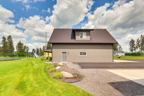 A two-story house with a front porch, a garage, and a well-maintained lawn. - Creekside Apartment in Kalispell on 5 Acres (Kalispell)