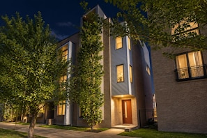 A modern multi-story residential building with a well-lit entrance and a visible door number. - Nashville-themed House 12 South Gulch Sleeps 12 (Nashville)