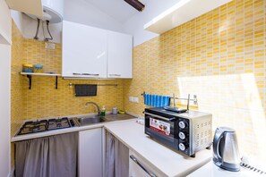 A kitchen with a gas stove, a toaster, and a kettle. - Alessio's House by Napoliapartments (Naples)