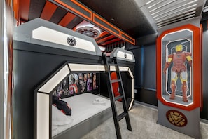 A bunk bed with a ladder, a wall with framed posters, and a display case with a figure. - Brand NEW 5BR w Pool Themed Rooms Lazy River 16220 (Clermont)