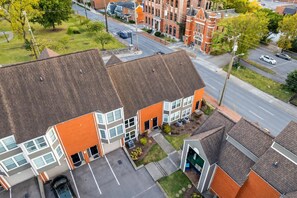 A multi-story residential building with a parking area, a driveway, and a street view. - Walkable Sobro House - Gated Parking - Sleeps 8 (Nashville)