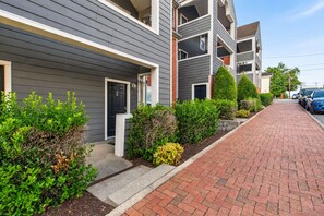 A row of modern multi-story residential buildings with a brick pathway and greenery. - Walkable Sobro House - Gated Parking - Sleeps 8 (Nashville)