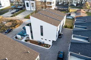 A modern two-story building with a flat roof, a driveway, and a parking area with several cars. - Skyline Views House - 4 Ensuites - Sleeps 12 (Nashville)