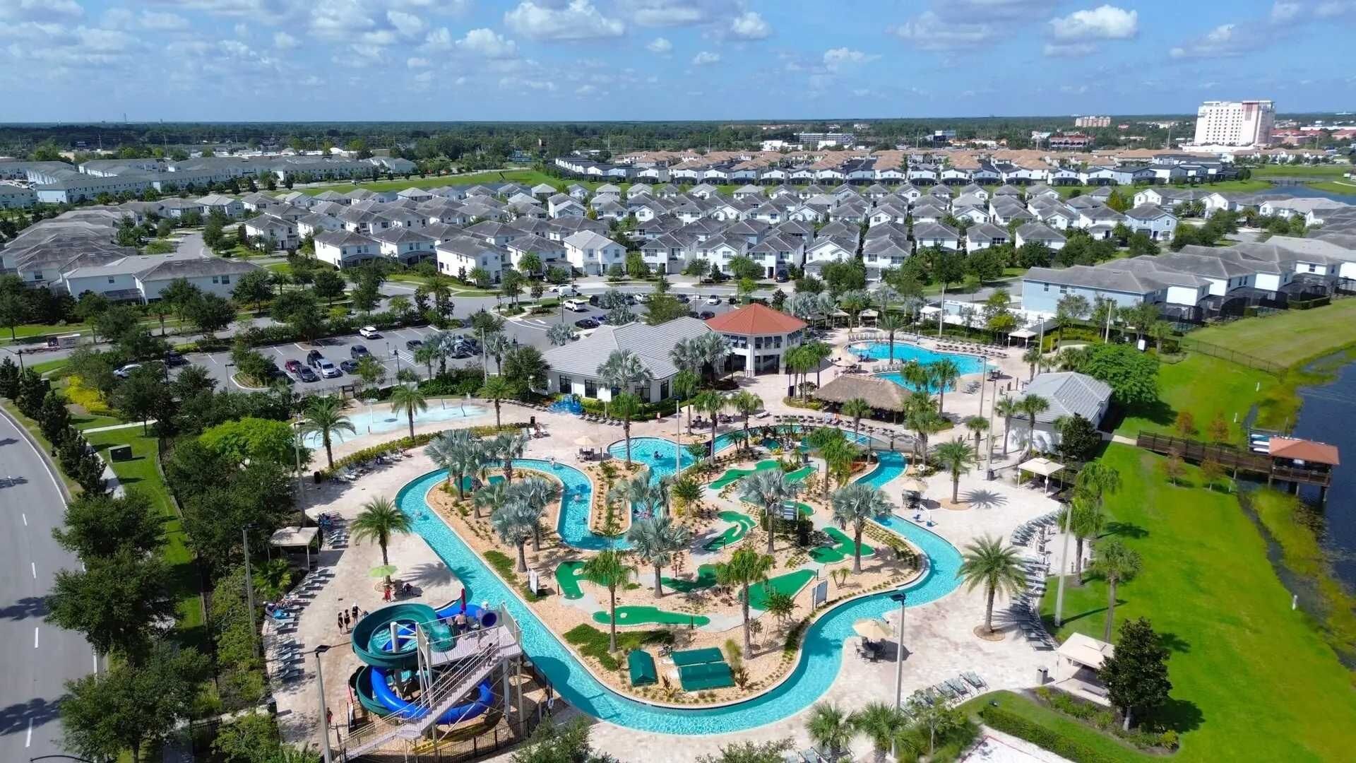 Een woongebied met een groot zwembadcomplex, inclusief een glijbaan en meerdere zwembaden.
