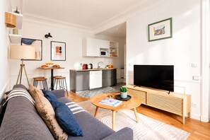 Ein modernes Wohnzimmer mit einer Couch, einem Couchtisch und einem Flachbildfernseher.