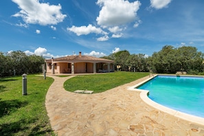 A house with a swimming pool, stone pathway, and a garden. - Villa With Private Pool Costa Rei (Muravera)