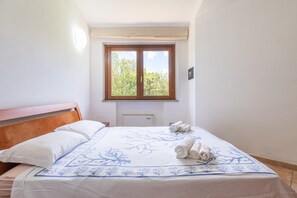 A bedroom with a bed, a window, and a radiator. - Villa With Private Pool Costa Rei (Muravera)