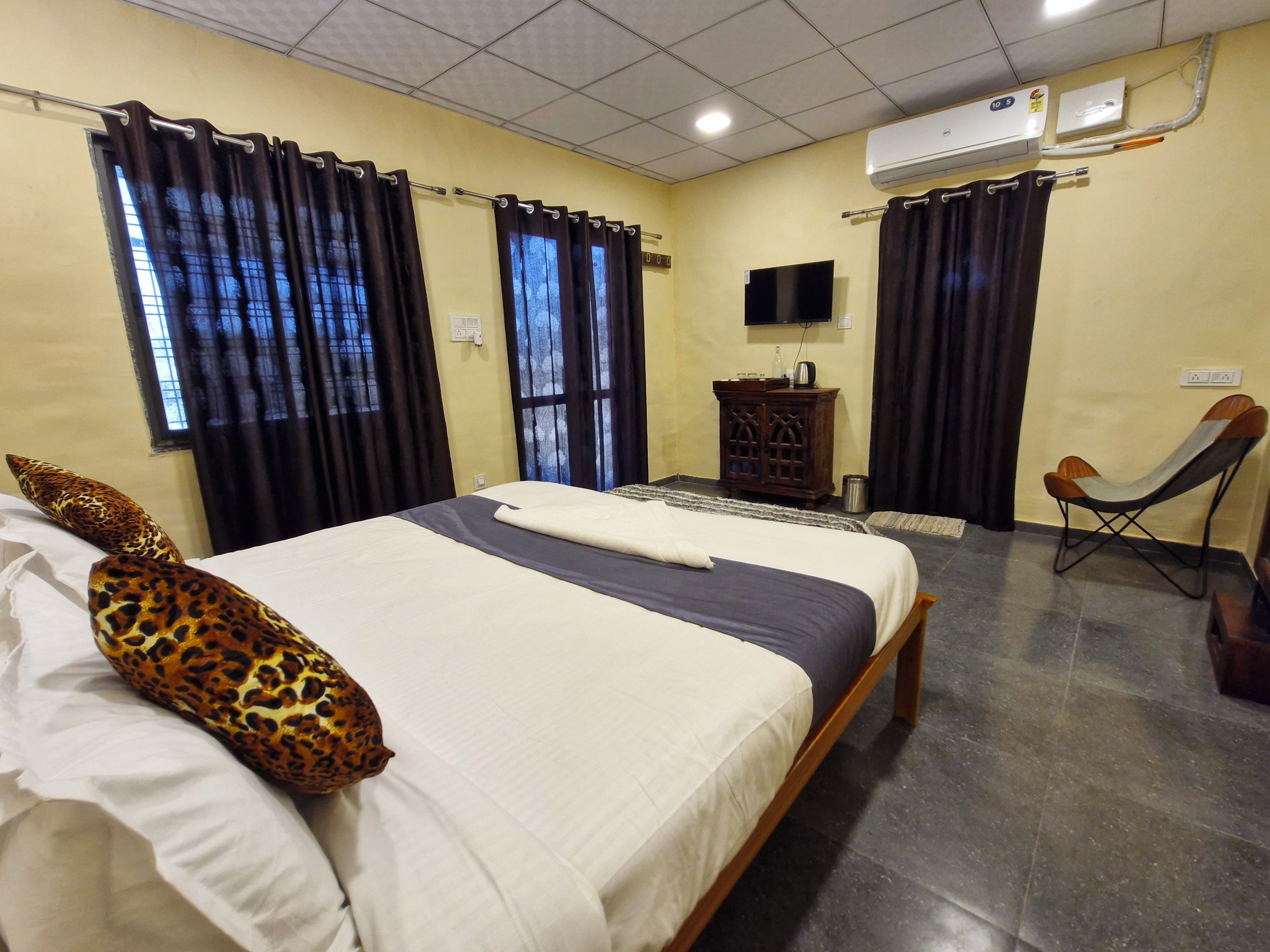 A hotel room with a bed, a television, a chair, and a cabinet.