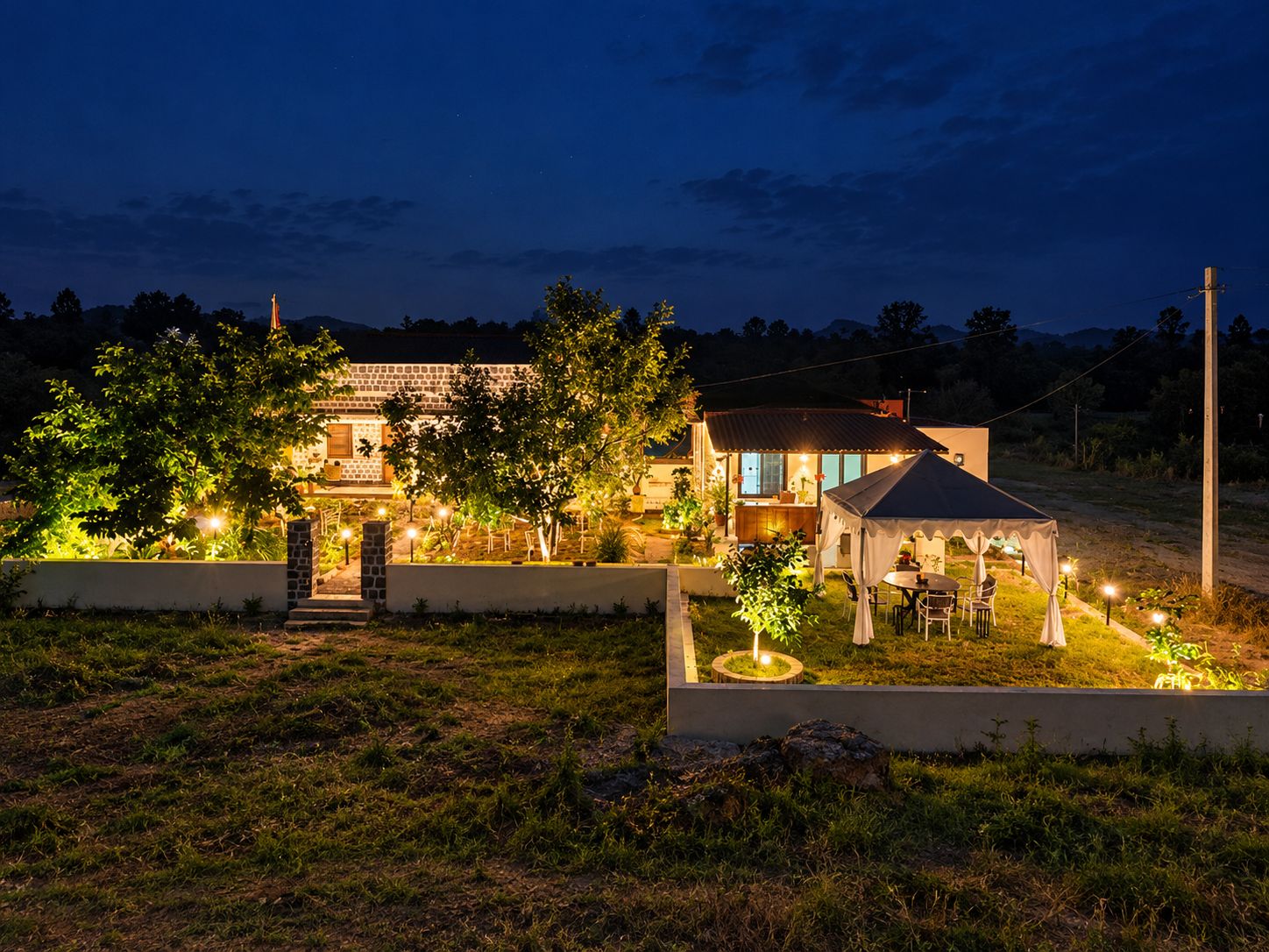 Una casa de piedra luminosa con jardín y una zona de estar cubierta al aire libre.