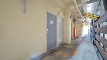 A corridor with doors marked 207, a wooden fence on the right, and a concrete floor with directional arrows.