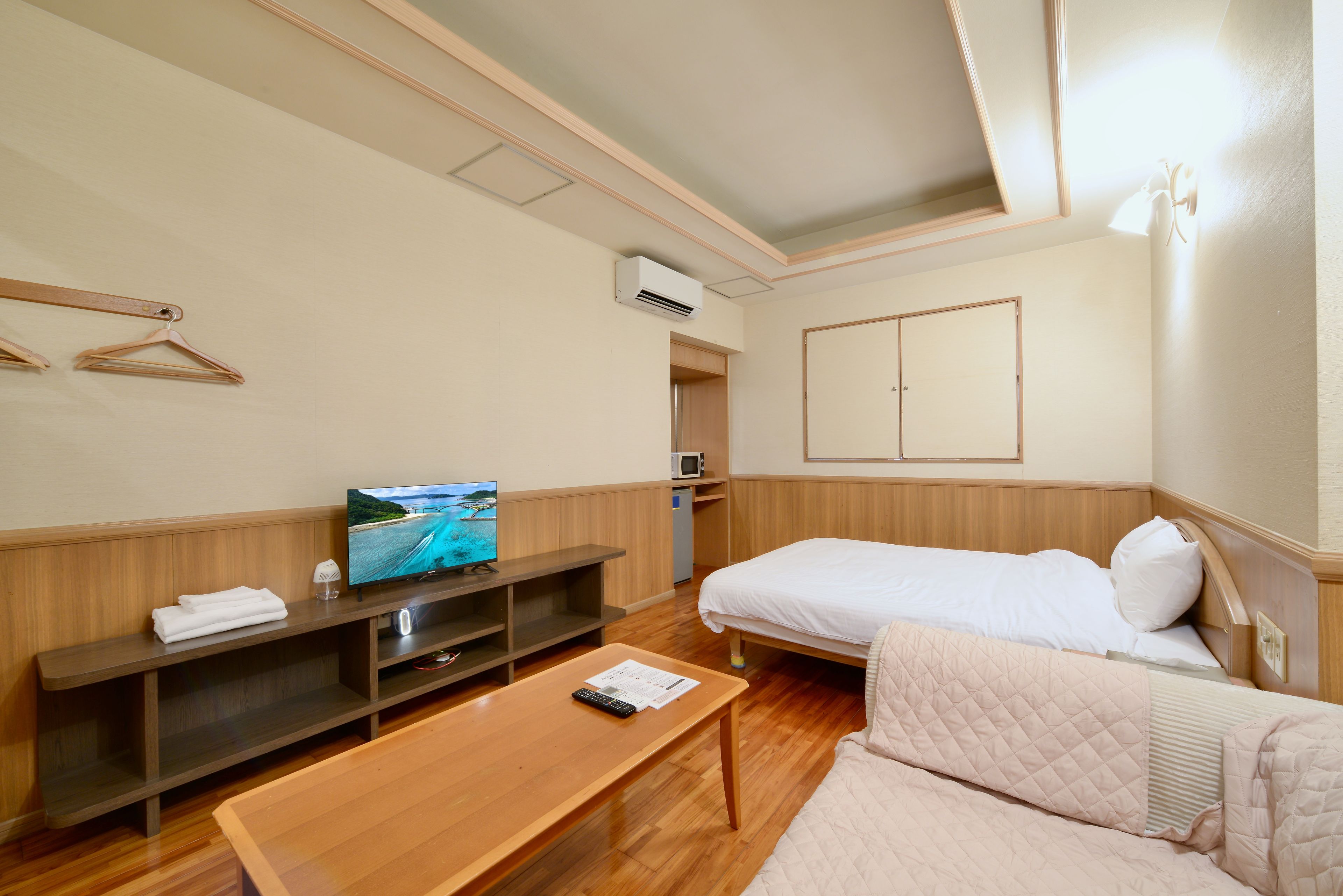 Habitación de hotel con cama, televisión, escritorio y zona de estar.