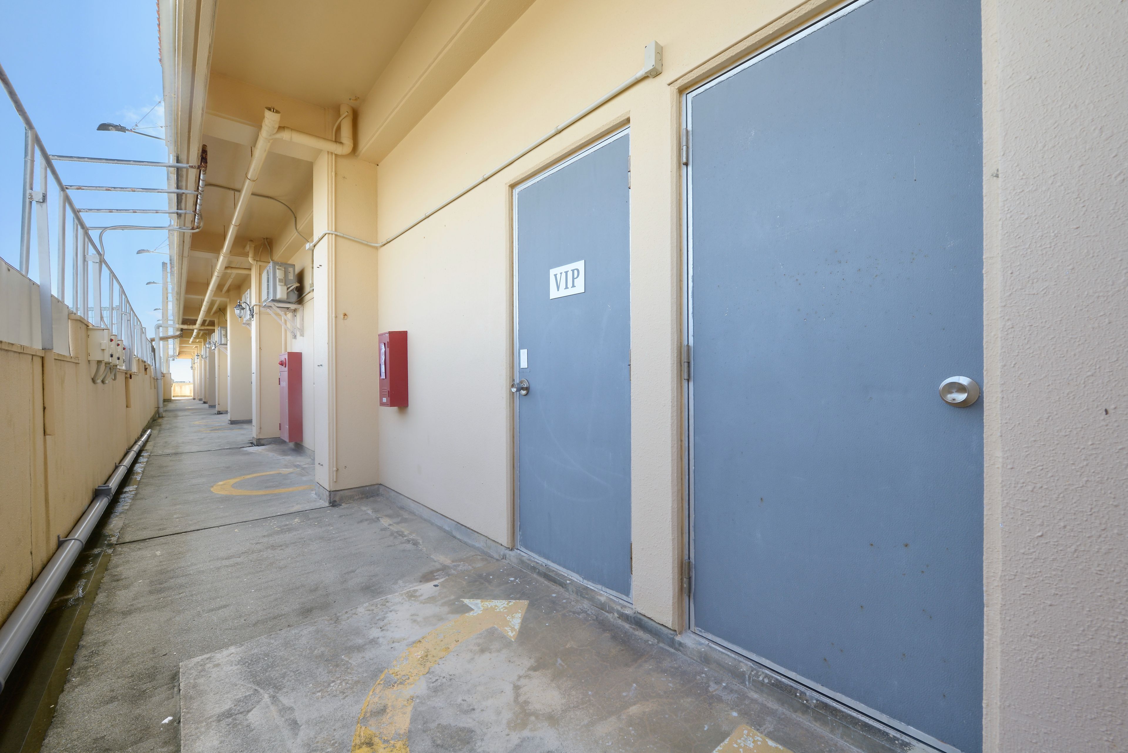 A corridor with doors marked 'VIP' and a clear path indicated by arrows on the floor.