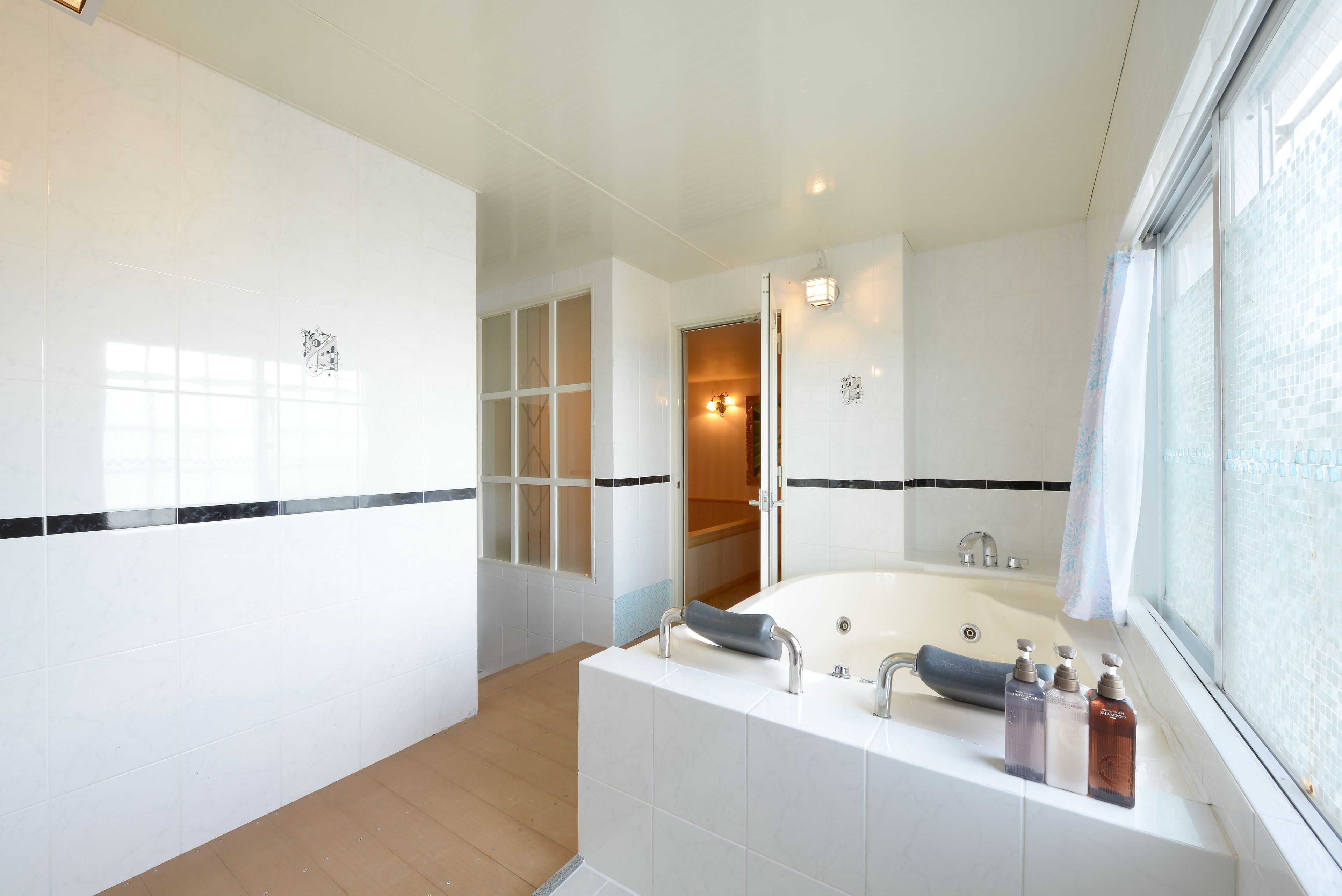 A modern bathroom with a bathtub, a shower, and a vanity with toiletries.