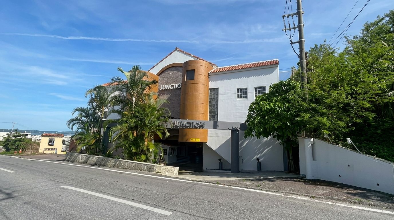 Un edificio con fachada curva y una estructura cilíndrica destacada, con un letrero que dice 'JUNCTION'.