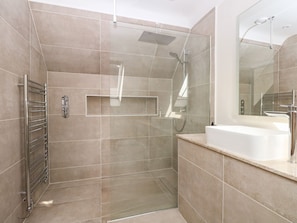 A modern bathroom with a glass-enclosed shower, a built-in sink, and a towel rack. - The Granary (Bordon)