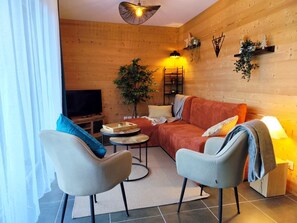 A cozy living room with a sofa, two armchairs, a coffee table, and a TV. - L'Alpin (4 People) Balcony with a view of the mountains—close to the train station and the gondola. Indoor parking. (Saint-Gervais-les-Bains)