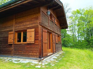 A wooden cabin with a front porch, large windows, and a chimney. - Le Mazot (sleeps 5) Mountain view, close to the slopes. Indoor parking. (Saint-Gervais-les-Bains)