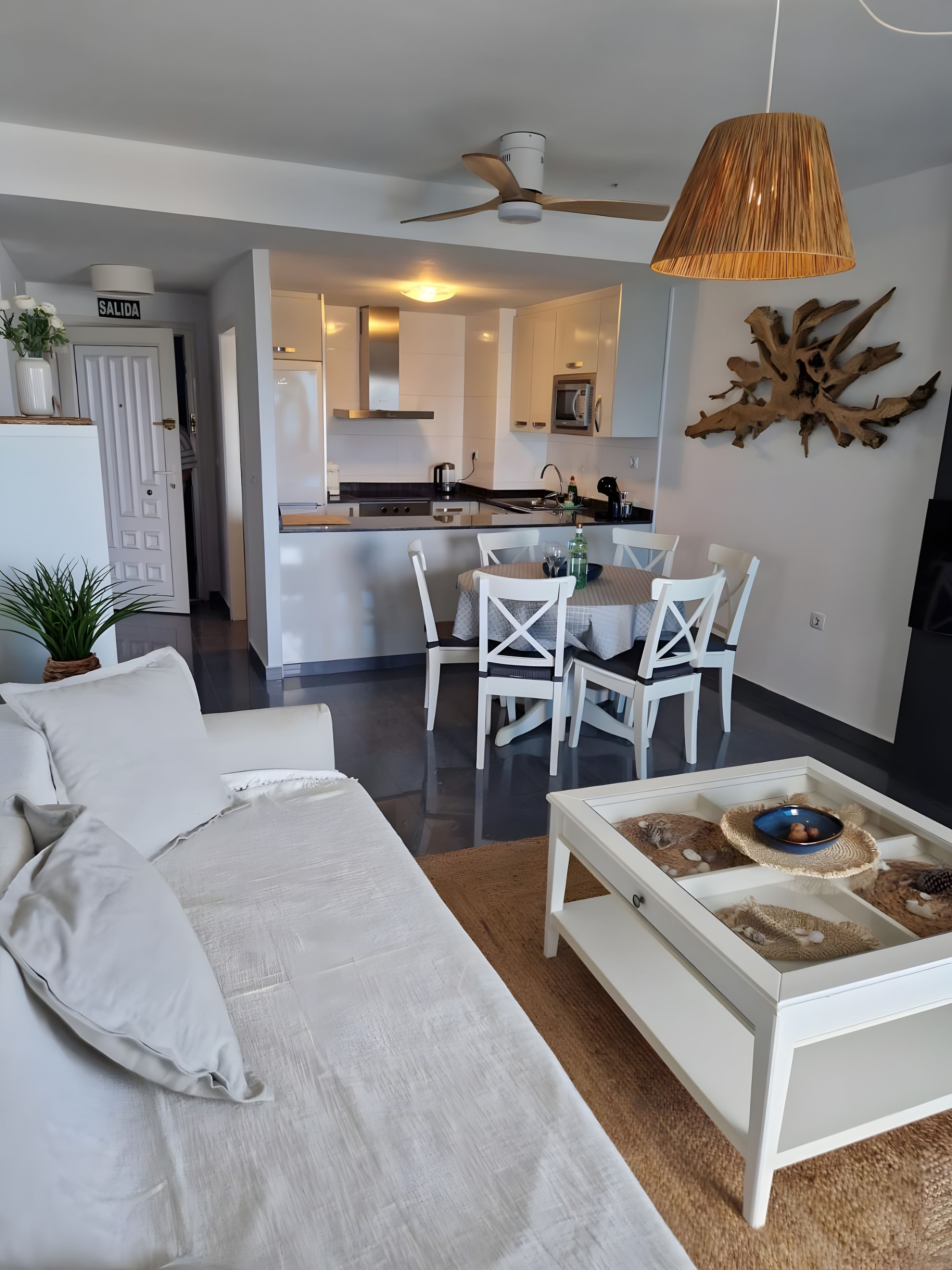 A modern living room with a sofa, coffee table, and dining area.