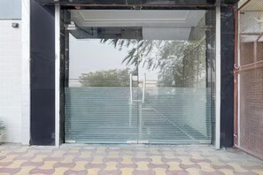 Una entrada de edificio con puerta de vidrio y reja de metal.